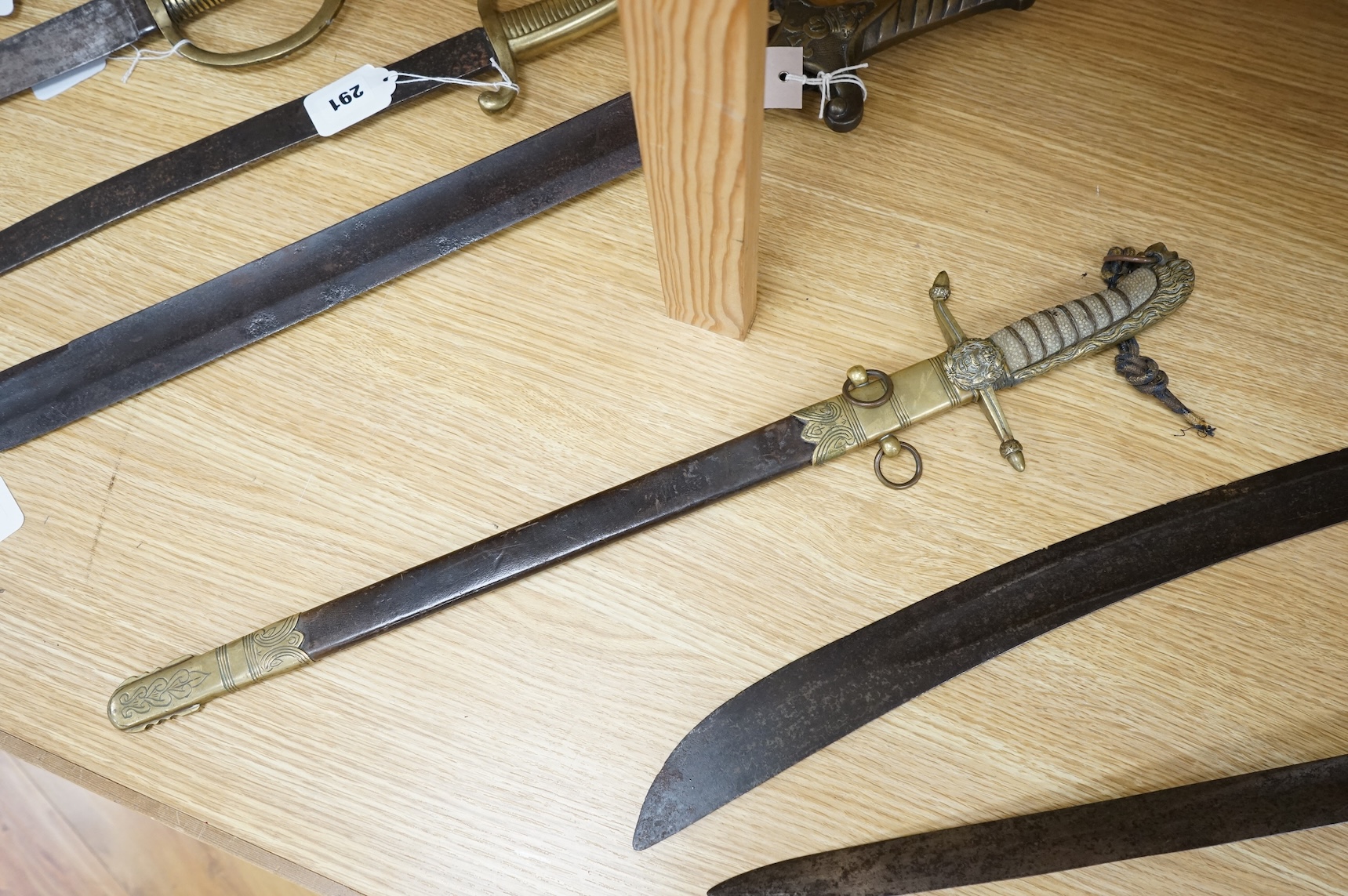 A post 1902 Naval Officer’s Dirk, the regulation blade with crowned fouled anchor, regulation hilt with remains of bullion dress knot in its leather scabbard with brass mounts, locket engraved with owners initials; RSA